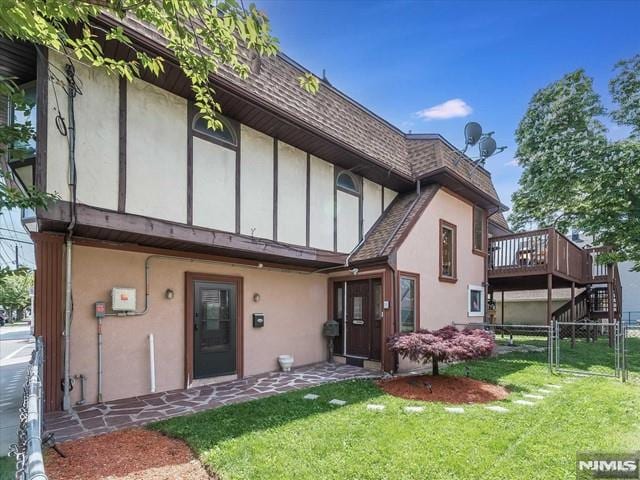 back of property featuring a yard and a wooden deck