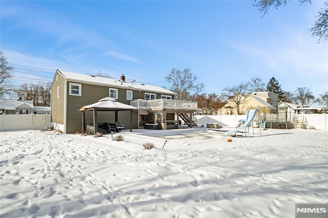 snow covered house featuring a deck and a gazebo