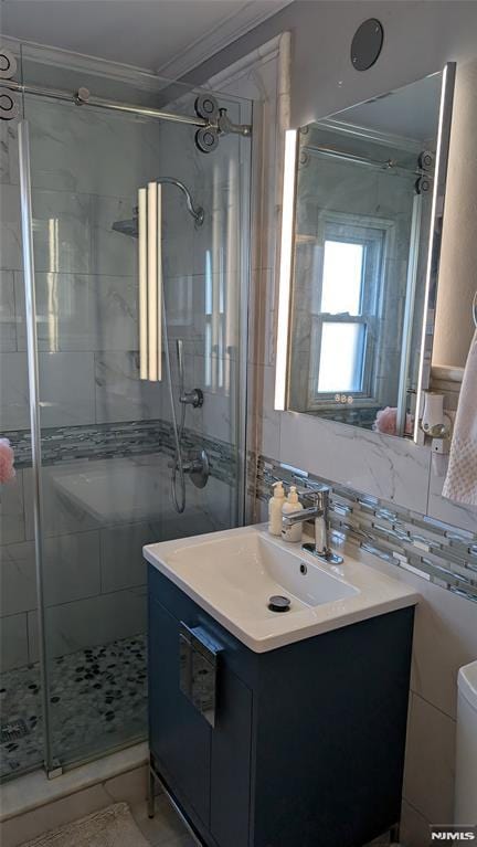 bathroom with vanity, a shower with shower door, crown molding, and tasteful backsplash