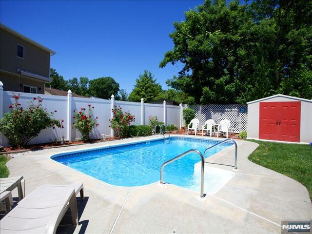 view of swimming pool with a patio area and a storage shed