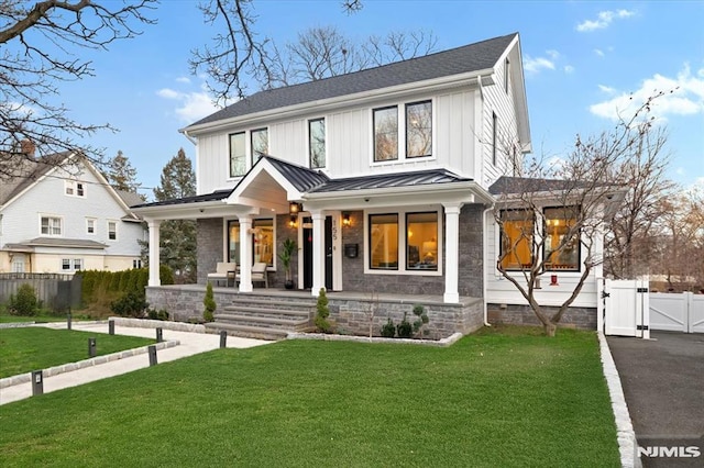 modern inspired farmhouse with a porch and a front lawn