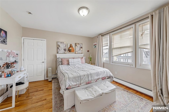 bedroom featuring a baseboard radiator and light wood-type flooring