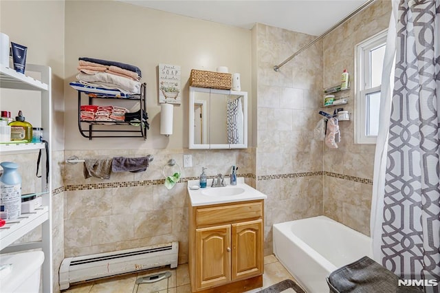 bathroom with shower / bath combo, vanity, baseboard heating, tile walls, and tile patterned flooring