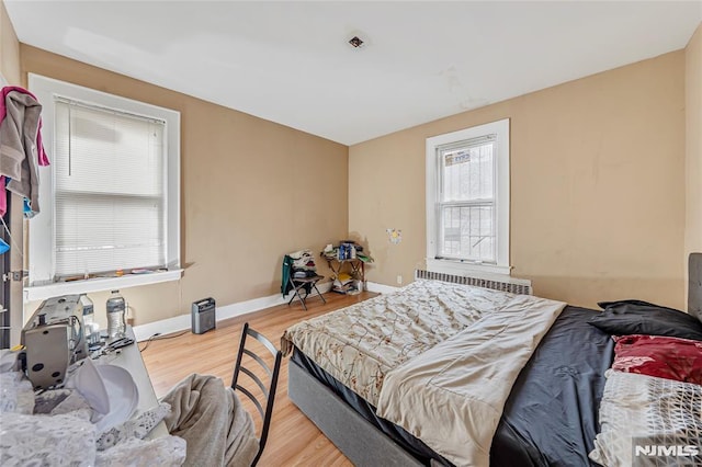 bedroom featuring hardwood / wood-style floors and radiator