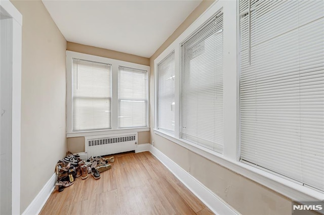 unfurnished sunroom with plenty of natural light and radiator