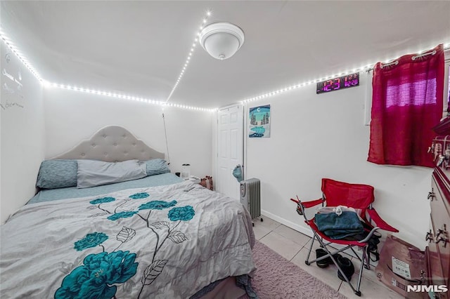 bedroom featuring radiator and light tile patterned flooring