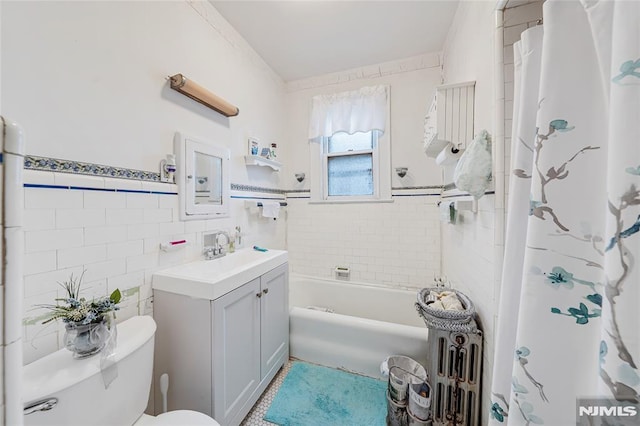 full bathroom with shower / tub combo, vanity, toilet, and tile walls