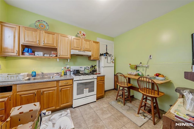 kitchen featuring sink, light tile patterned floors, and white appliances