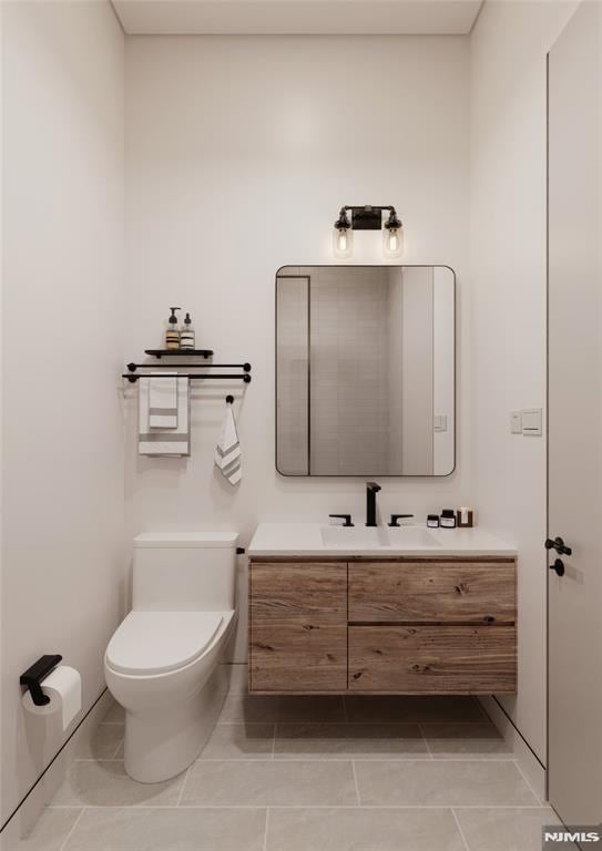 bathroom featuring toilet, vanity, and tile patterned flooring