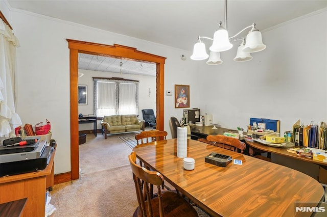 dining area featuring light colored carpet, crown molding, and an inviting chandelier