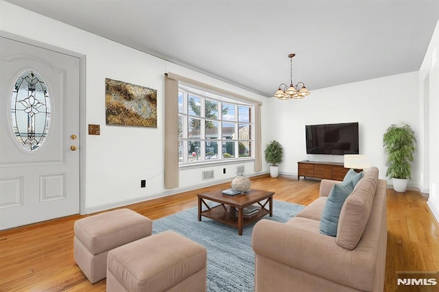 living room with a chandelier and light hardwood / wood-style flooring