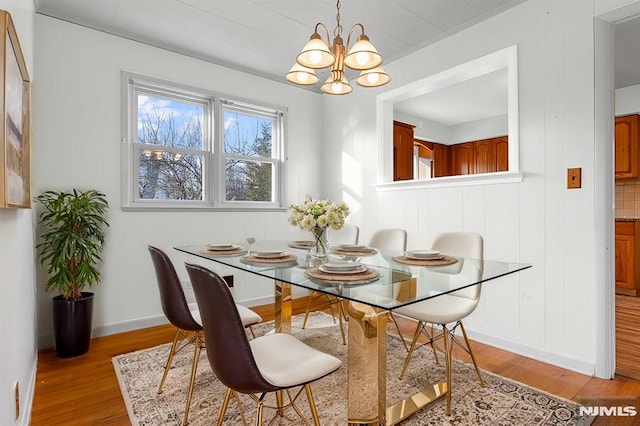 dining area with a notable chandelier and light hardwood / wood-style flooring