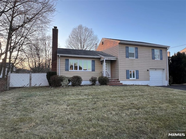 tri-level home featuring a yard and a garage