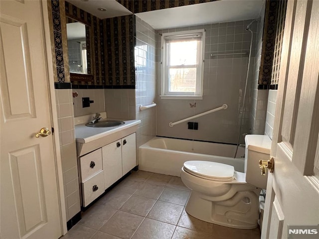 full bathroom featuring tile patterned floors, vanity, tiled shower / bath combo, and toilet