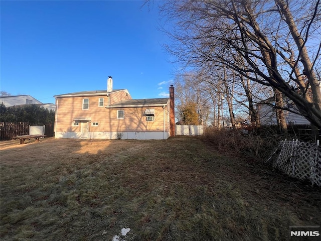 rear view of house featuring a yard