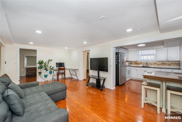 living room with sink and light wood-type flooring