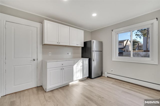 kitchen featuring light hardwood / wood-style floors, stainless steel fridge, white cabinetry, and a baseboard radiator