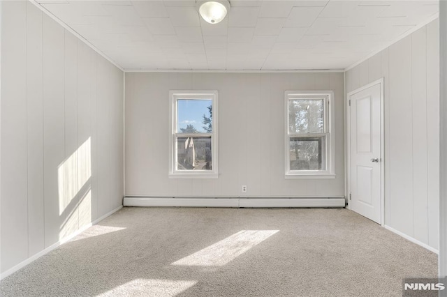 spare room with ornamental molding, light carpet, and a baseboard heating unit