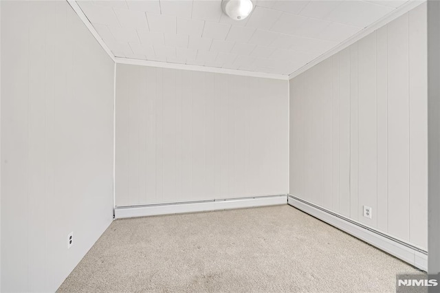 empty room featuring light colored carpet, wood walls, ornamental molding, and a baseboard radiator