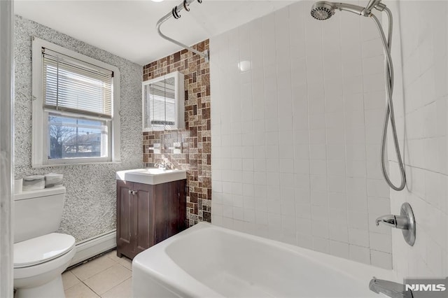 full bathroom featuring baseboard heating, toilet, tile patterned floors, vanity, and tiled shower / bath combo