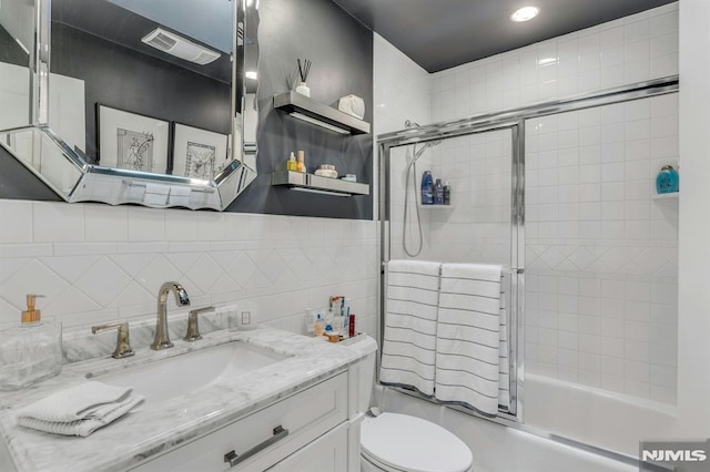 full bathroom with toilet, vanity, decorative backsplash, and tiled shower / bath combo