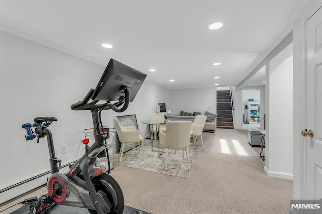 workout room featuring baseboard heating, light carpet, and crown molding