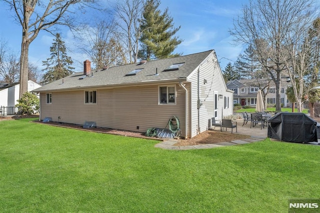 rear view of property with a yard and a patio