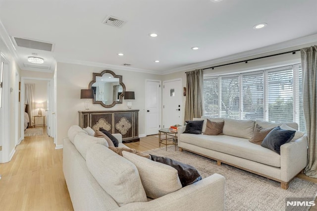 living room with ornamental molding and light hardwood / wood-style floors