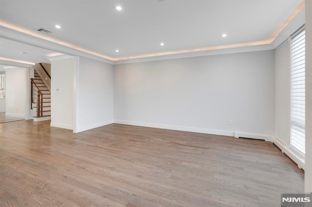 empty room with light hardwood / wood-style floors and ornamental molding