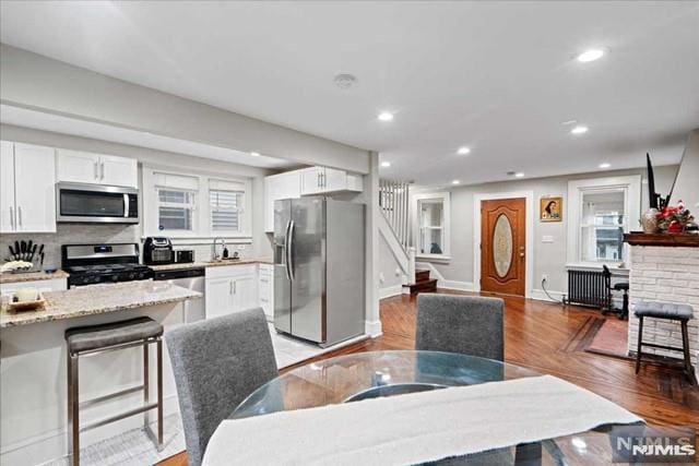 dining room featuring hardwood / wood-style flooring, sink, and a wealth of natural light