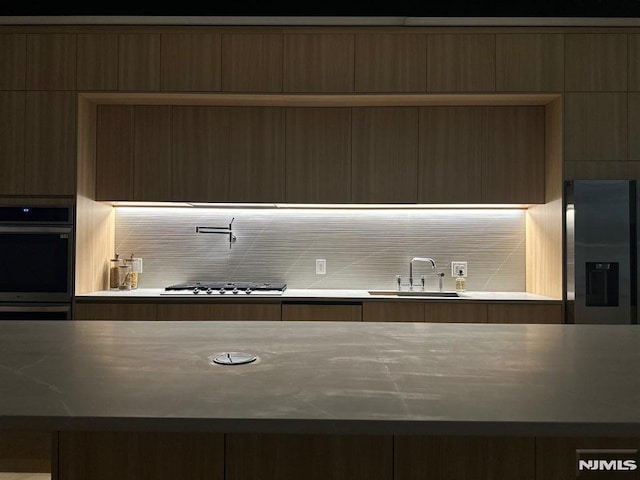 kitchen with decorative backsplash, stainless steel appliances, and sink