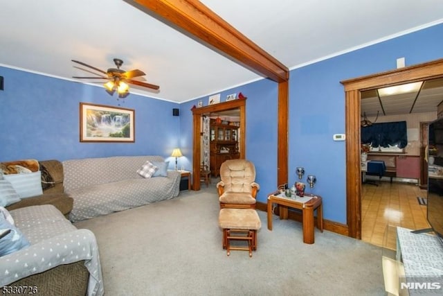 living room with beam ceiling, ceiling fan, and crown molding