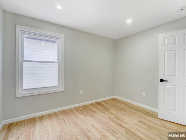 empty room featuring light wood-type flooring and a healthy amount of sunlight