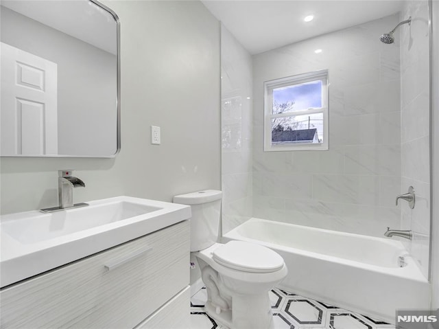 full bathroom featuring toilet, vanity, and tiled shower / bath