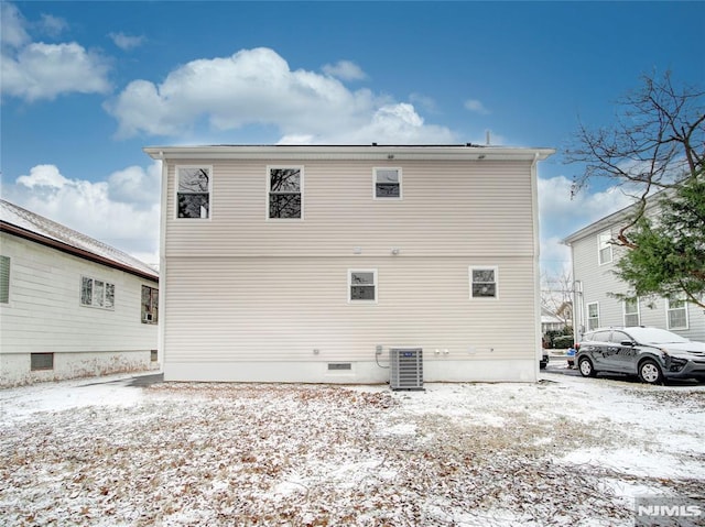 snow covered rear of property featuring central air condition unit