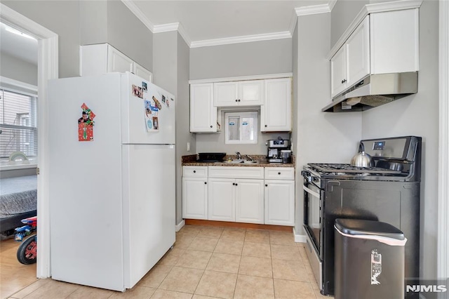 kitchen with white cabinetry, stainless steel gas stove, white fridge, dark stone counters, and light tile patterned floors