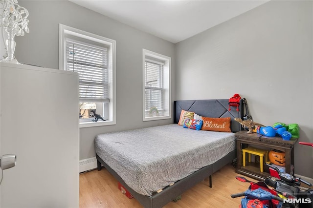 bedroom featuring a baseboard radiator and light hardwood / wood-style flooring