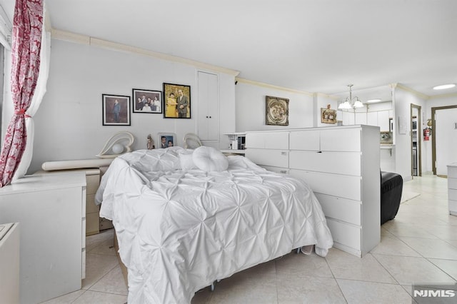 bedroom with light tile patterned floors, a notable chandelier, and ornamental molding