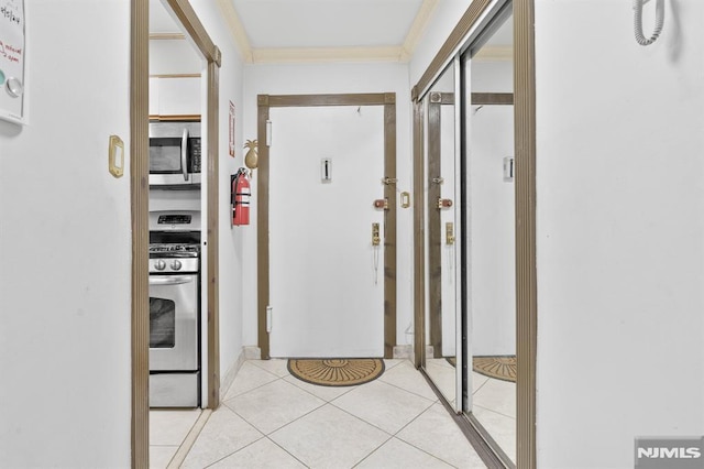 hallway featuring crown molding and light tile patterned flooring