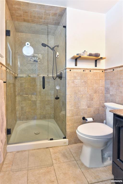 bathroom featuring walk in shower, vanity, tile walls, and toilet