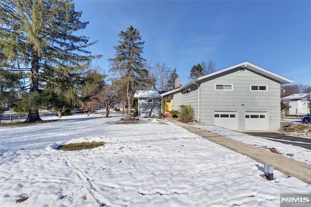 view of snow covered exterior featuring a garage