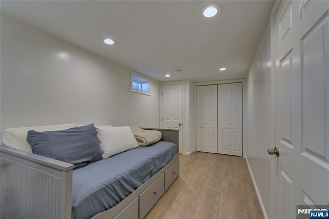 bedroom with light wood-style floors, baseboards, a closet, and recessed lighting