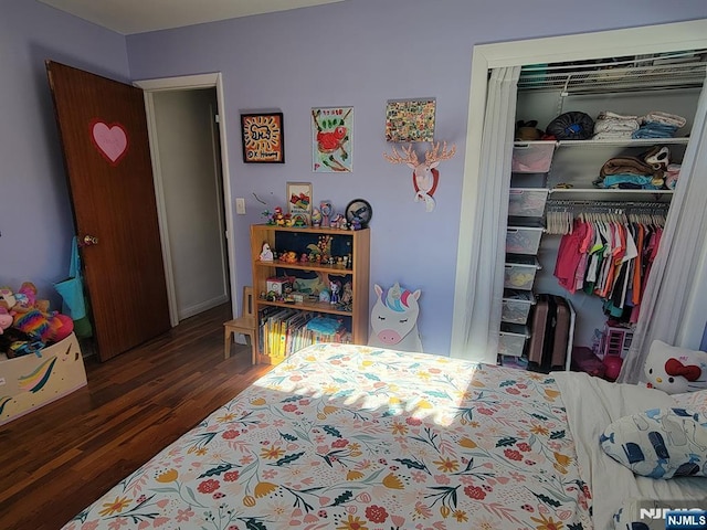 bedroom with dark wood finished floors and a closet