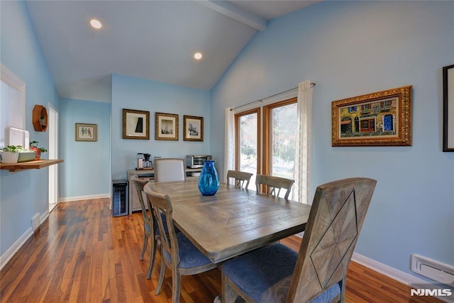 dining space featuring beam ceiling, baseboard heating, dark wood-type flooring, and high vaulted ceiling