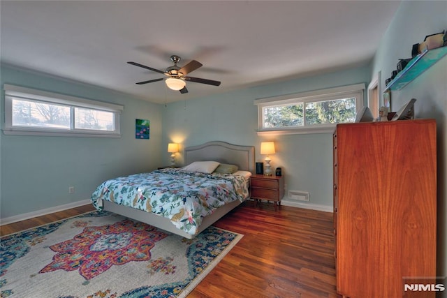 bedroom featuring multiple windows, dark hardwood / wood-style flooring, and ceiling fan