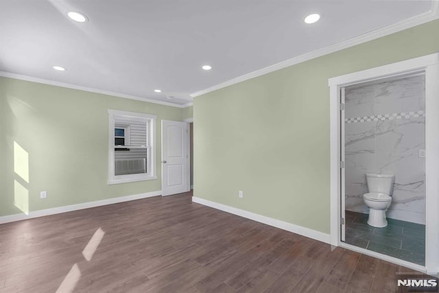 unfurnished bedroom with connected bathroom, ornamental molding, and dark hardwood / wood-style floors