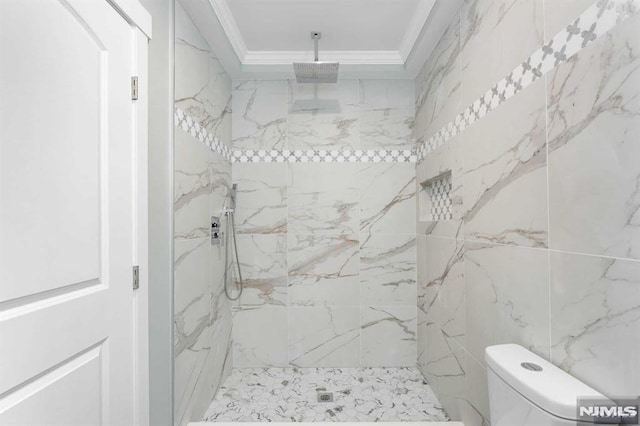 bathroom with tiled shower, ornamental molding, and toilet