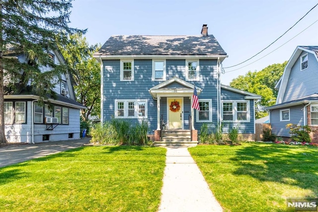 colonial house featuring a front yard and cooling unit