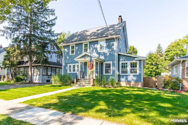 colonial-style house featuring a front yard