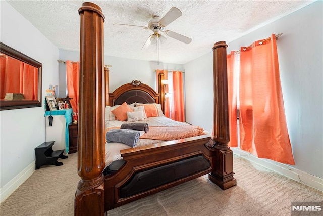 carpeted bedroom with ceiling fan and a textured ceiling